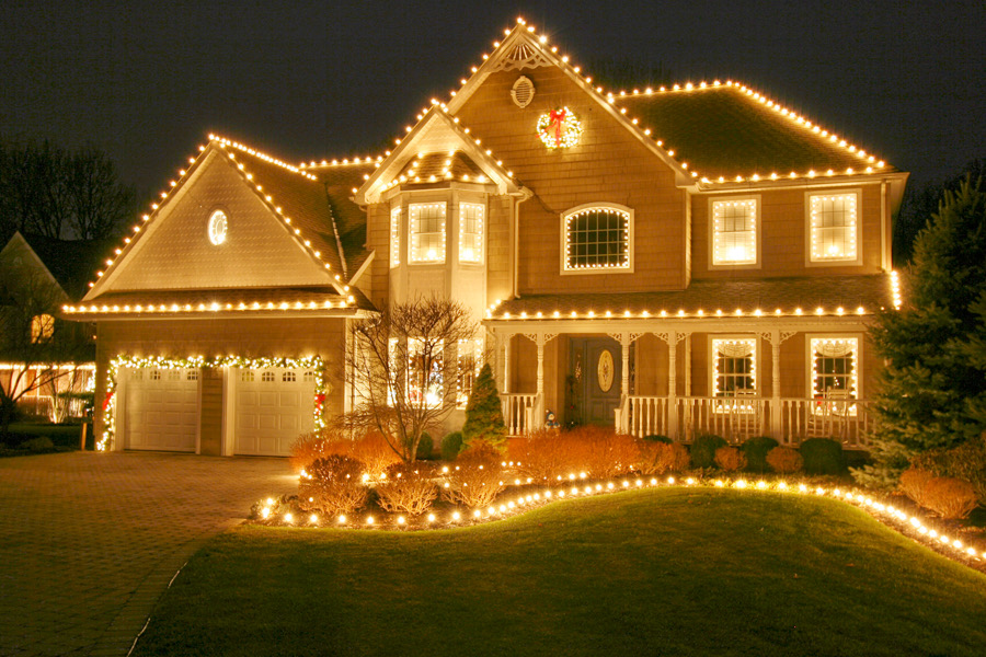 Professional holiday lighting installation on a San Antonio home with warm gold lights along the roofline, soffit, and landscaping