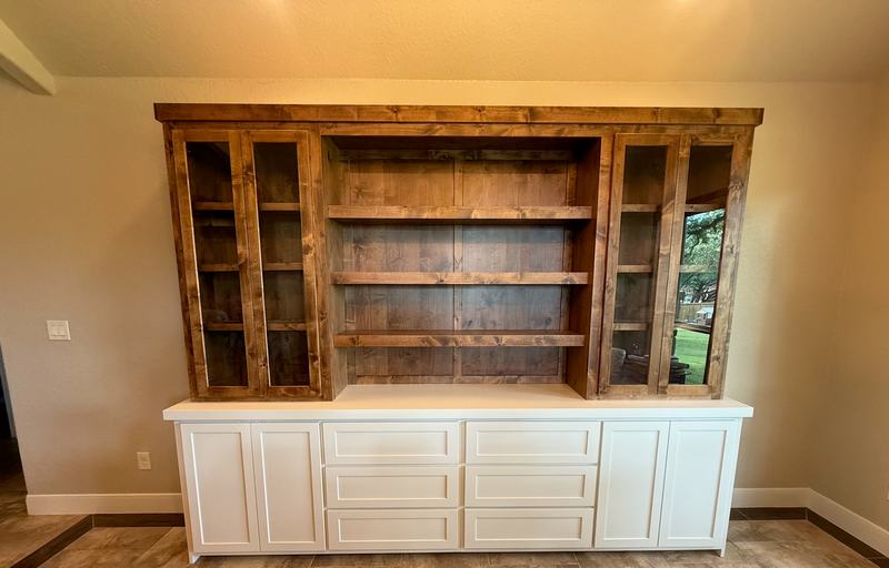 Knotty alder hutch with glass doors and open shelves set on a white painted base of doors and drawer banks