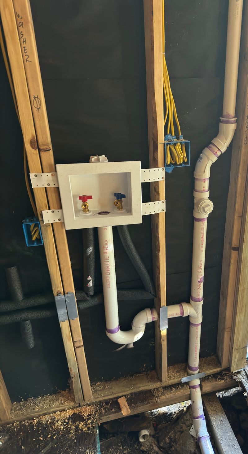 Laundry rough-in with a washer outlet box, PVC trap, drain and vent in an open stud wall