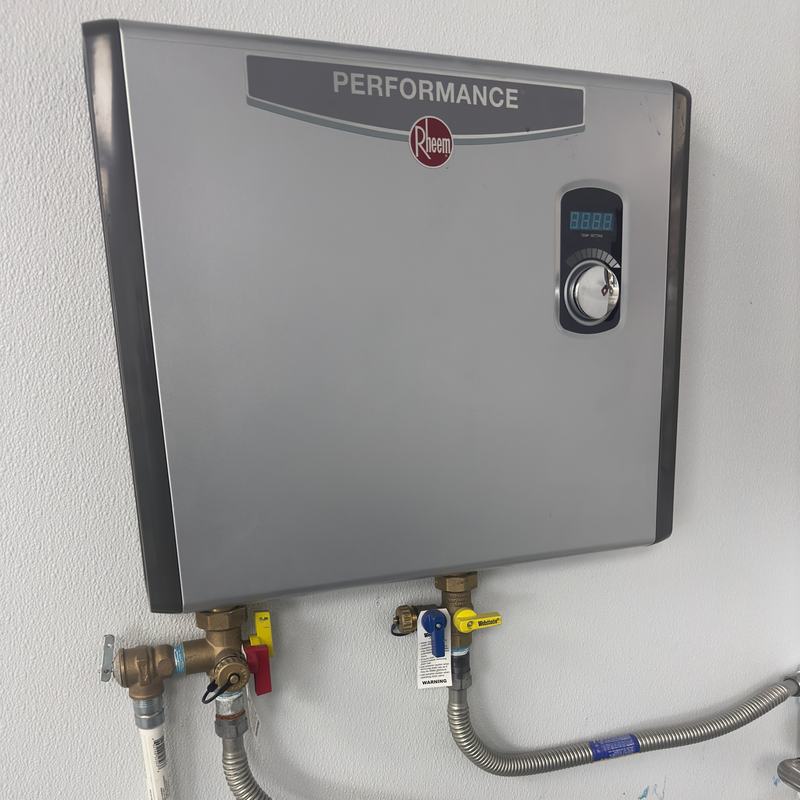 Wall-mounted electric tankless water heater with brass isolation valves, a relief valve and flexible stainless supply lines