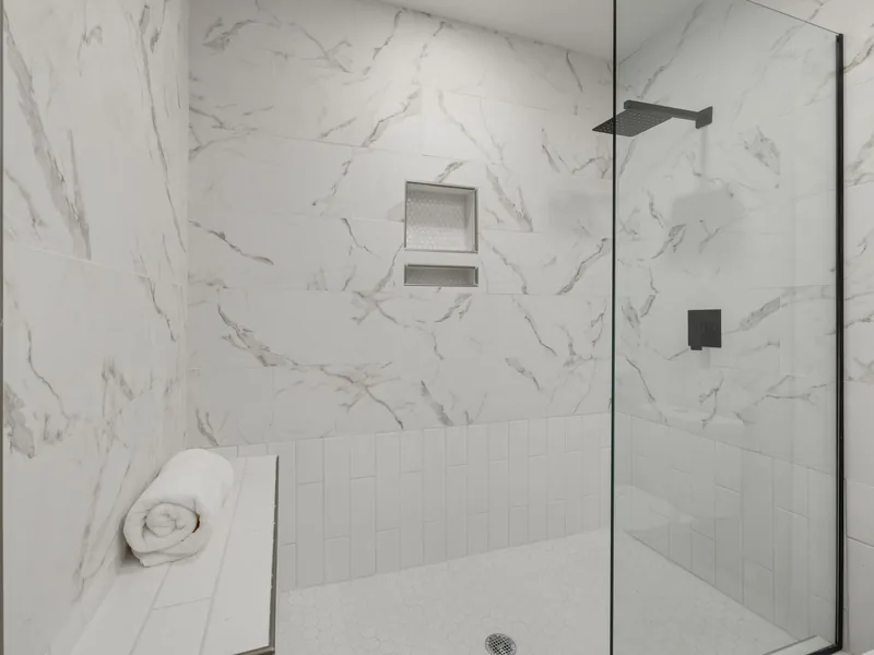 White marble walk-in shower with a glass panel and bench