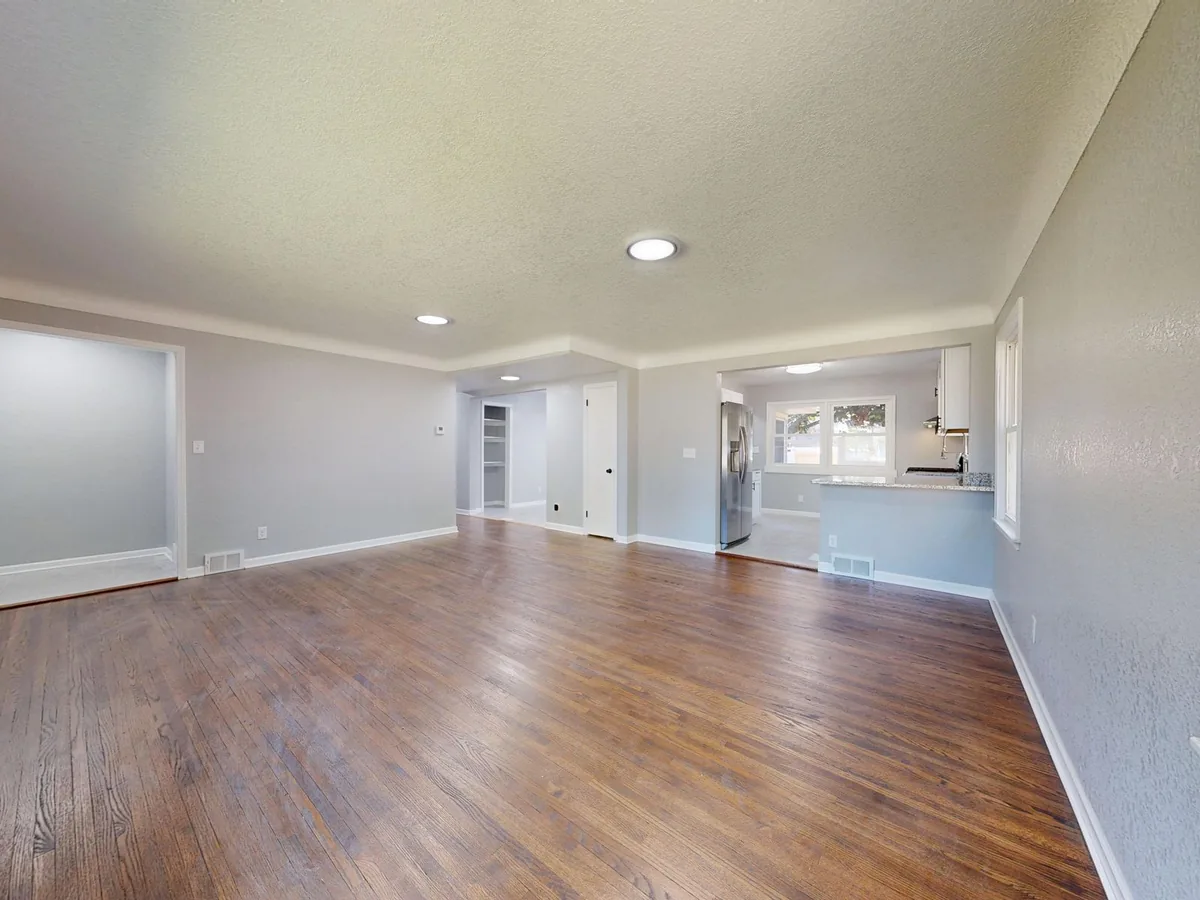 Empty room with hardwood floors and recessed lighting