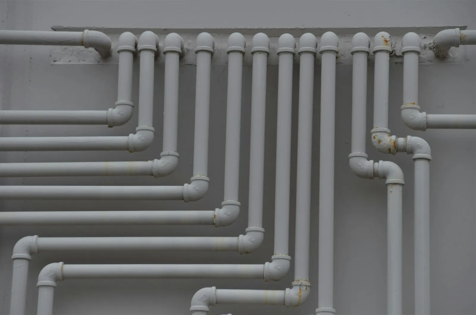 White water supply pipes running along a wall
